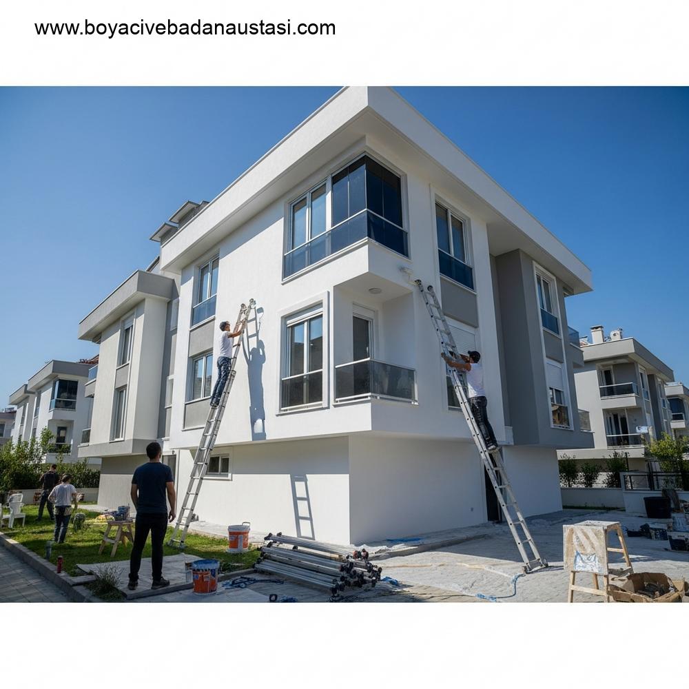 Güneşli havada yeni boyanmış modern bir konut binasının dış cephe yenileme sonrası görüntüsü, profesyonel ekipmanlar yakında düzenli bir şekilde toplanmış durumda.