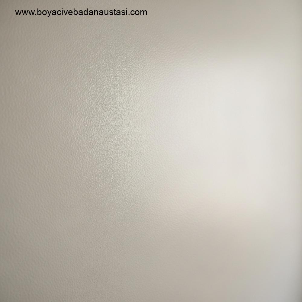 İzmir'de parlak bir oturma odasında yeni boyanmış, mat dokulu, silikonlu iç cephe boyasının yakın çekim fotoğrafı.